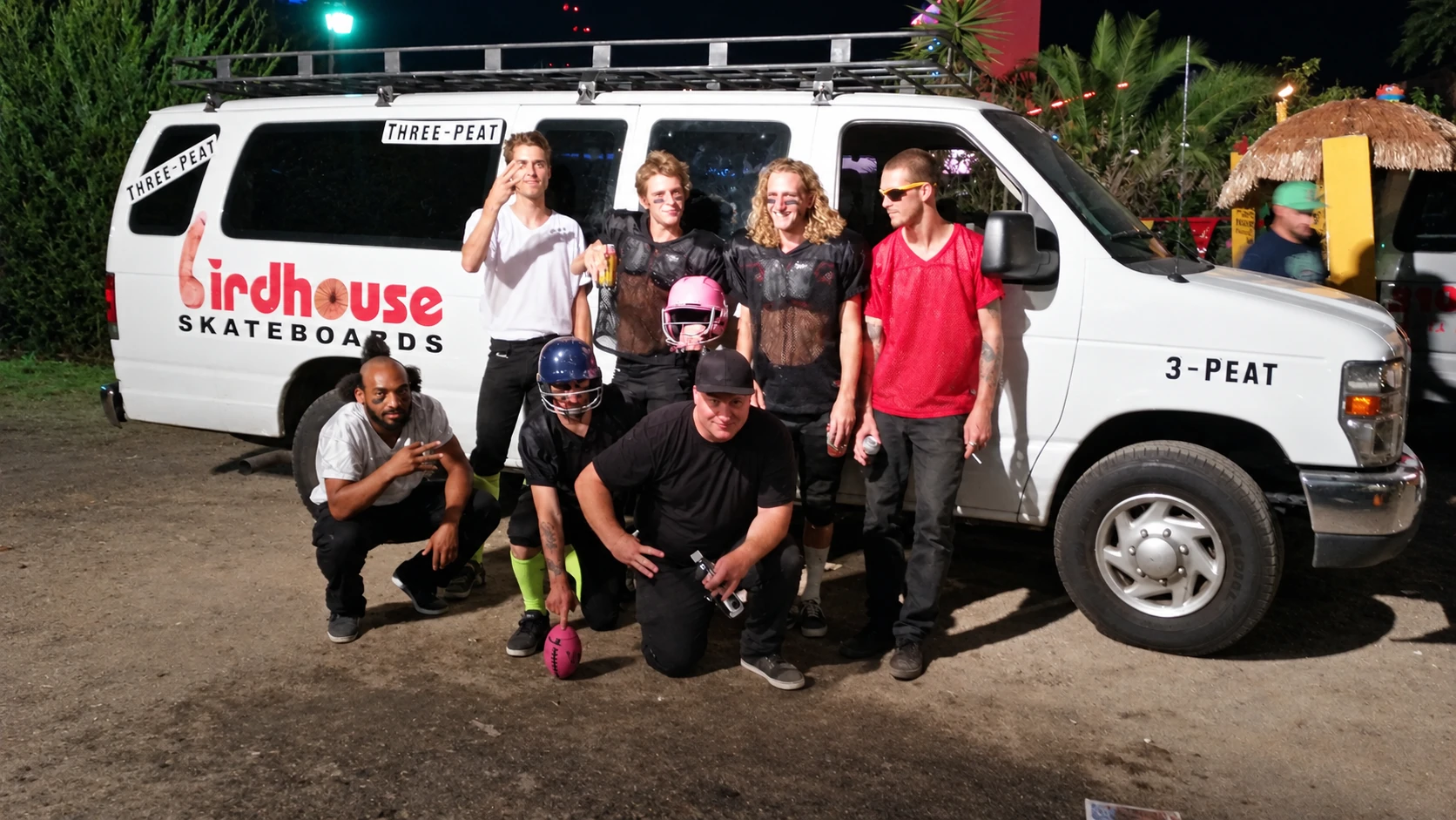 A behind-the-scenes group photograph beside the Birdhouse Skateboards van during King of the Road production.